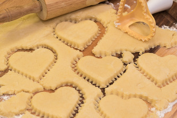 Hearts shaped cookie cutter on raw cookie dough. Closeup.