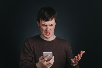 Guy I saw on the screen of a mobile phone shocking news, closeup portrait in Studio