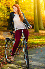 Fototapeta na wymiar Beauty girl relaxing in autumn park with bicycle, outdoor