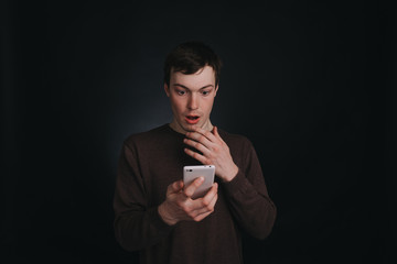 Guy I saw on the screen of a mobile phone shocking news, closeup portrait in Studio