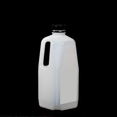 white Plastic bottle of milk on black background.