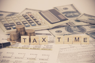 wording tax and calculator with tax documents and money on table. Tax concept.