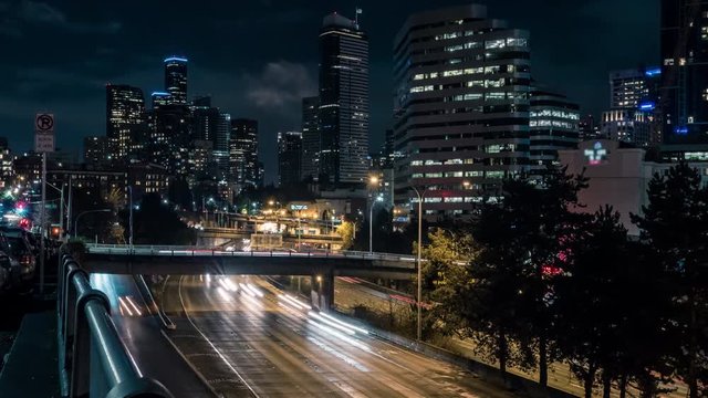 American City Night Time-Lapse of Freeway Cars and Skyscraper Buildings
