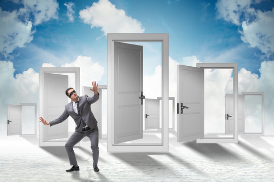 Confused businessman in front of doors