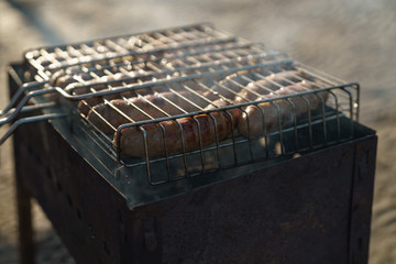 cooking bbq sausages on a beach