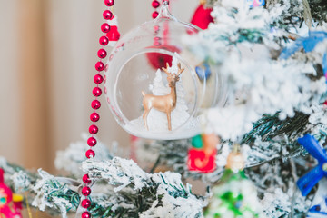 Figurine of deer in glass bowl weighs on Christmas tree