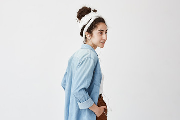 Profile of female teenager listening to music or audio book while going to university, having happy expression, laughing, isolated against white background. Music and relaxation concept © Cookie Studio