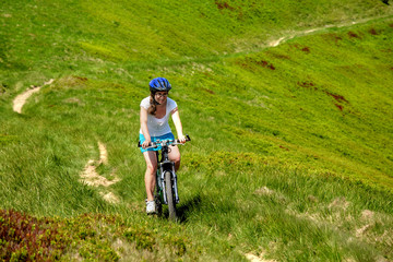 Fototapeta na wymiar Woman rides bicycle up in the mountains