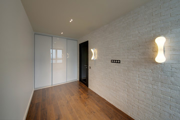 The room with a brick white wall and a white case