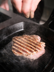 Vegans hide - here goes meat. Chef holding a piece of grilled beef. Tasty restaurant dish concept