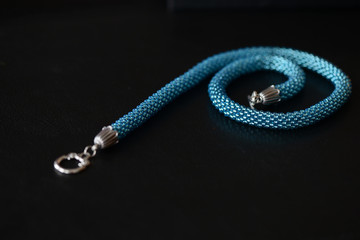 Fototapeta premium Beaded necklace of turquoise color on a dark background close up