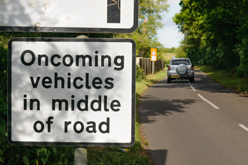 Naklejka premium Road sign warning drivers that oncoming vehicles will be in the middle of the road
