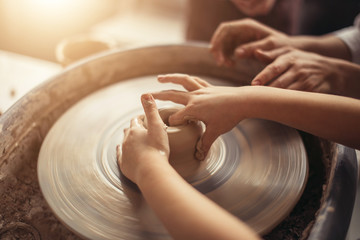 Female potter working at throwing wheel at studio. Clay workshop