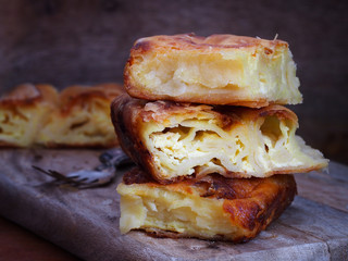 Homemade cheese strudel on wooden background. Traditional Croatian snack called Masnica, sweet or salty.
