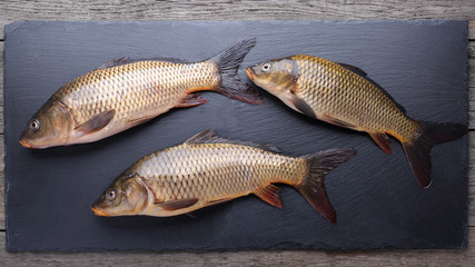 Fresh carps on black cutting board