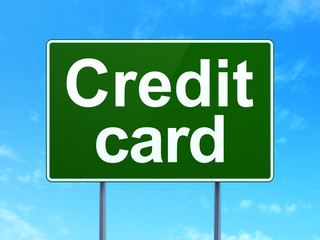 Money concept: Credit Card on green road highway sign, clear blue sky background, 3D rendering