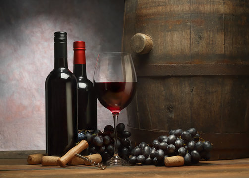  Picture with wine bottles, wineglass of red wine, wooden old barrel and dark grape