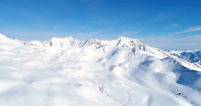 Montagnes couvertes de neige sous un ciel bleu. Ce sont les Alpes en France, parfait pour skier and voyager/faire du tourisme - vue a&eacute;rienne avec un drone  - Concept de paysage