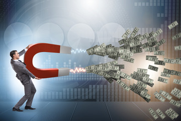 Businessman catching dollars on horseshoe magnet