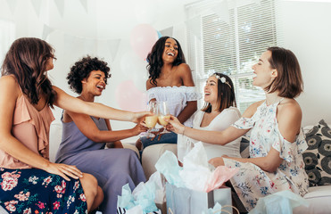 Friends celebrating baby shower with juices - obrazy, fototapety, plakaty