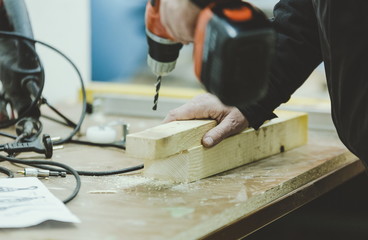 Master carpenter working on woodwork using electric tools