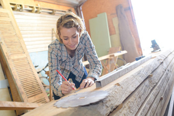 female carpenter draws sketches in pencil in a notebook