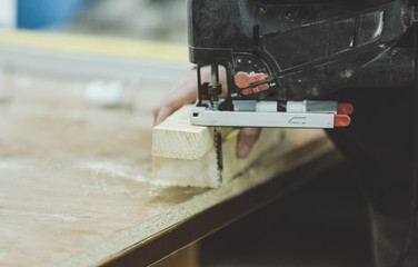 Master carpenter working on woodwork using electric tools