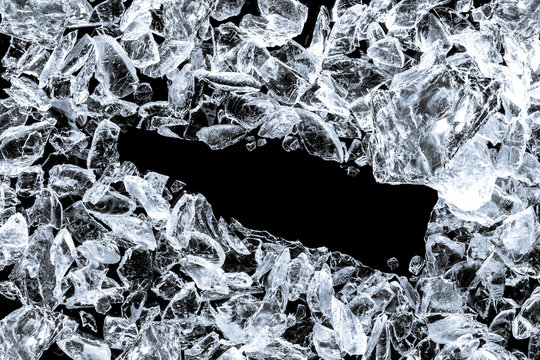Pieces of crushed ice cubes on black background. Empty space in the center in form of bottle.