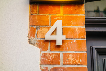 steel number 4 door sign on brick facade