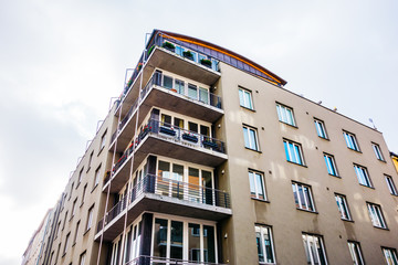Fototapeta na wymiar old brown apartment building with corner balcony