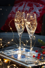 Postcard with Christmas shampagne glasses on the handmade tray over the red and white embroidered pillow with deer