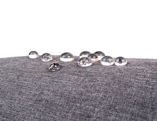Gray waterproof fabric with waterdrops close up on white background