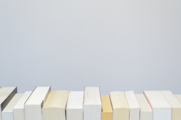 Books in a row on light grey background