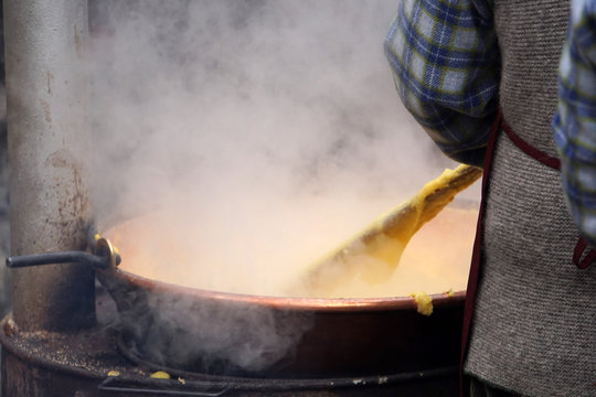 RANGO, ITALY - DECEMBER 8, 2017 - People cooking polenta traditional corn wheat meal