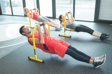 group of happy european people exercising in gym club