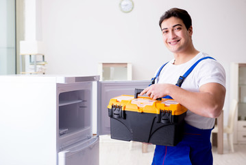 Repairman contractor repairing fridge in DIY concept