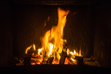 Orange flames of fire in fireplace, background, orange