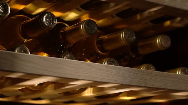 Closeup Wine Bottles Lie Necks Forward in Fridge for Storing
