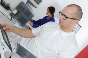 technician using tablet pc while analysing server