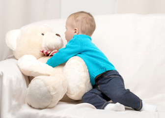 Little boy playing with teddy bear