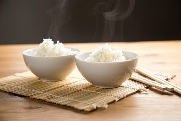 Zwei Schalen Basmati Reis mit Stäbchen auf Matte