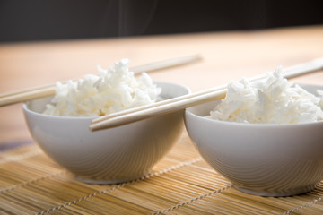 Zwei Schalen Basmati Reis mit Stäbchen auf Matte