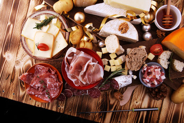 assorted cheese,meats and bread on wooden background