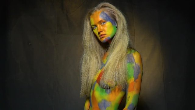 Strange naked girl in multi-colored body art, slow motion