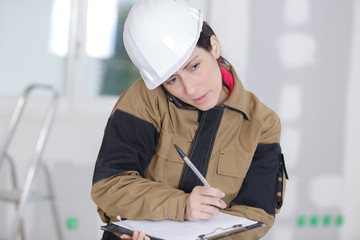 woman builder writes on her clipboard