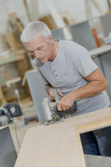 Senior carpenter using a circular saw