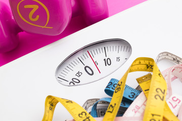 scales with measuring tapes and weights of the gym, concept of diet and beauty