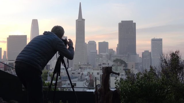 A local photographer capturing the skyline sunrise from a tucked-away scenic viewpoint on Telegraph hill., San Francisco