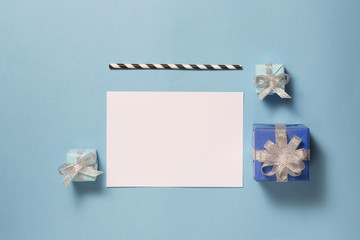 Christmas ore New Year background with blank note and red gifts over blue.