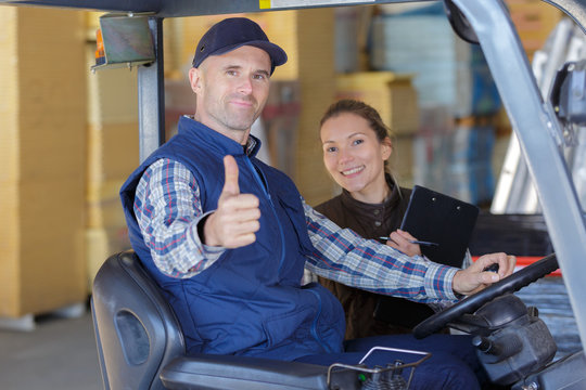warehouse worker and his manager smiling at camera